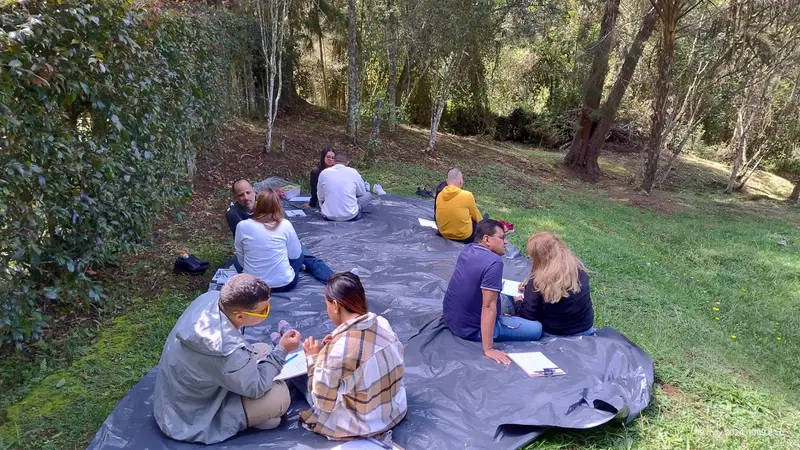 Parejas realizando un ejercicio por parejas sobre una lona en un jardín del retiro