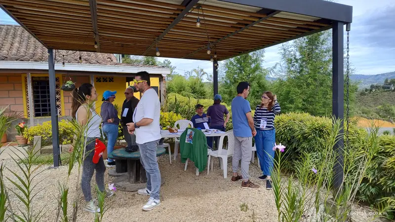 Participantes conversando bajo la pérgola de la finca
